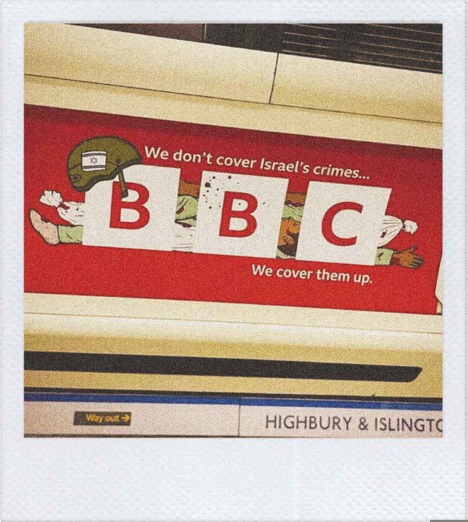 L'immagine mostra un cartellone nella metropolitana di Londra. Il logo della BBC copre il disegno di alcune persone morte, il testo riporta: "We don't cover Israel's crimes... We cover them up."